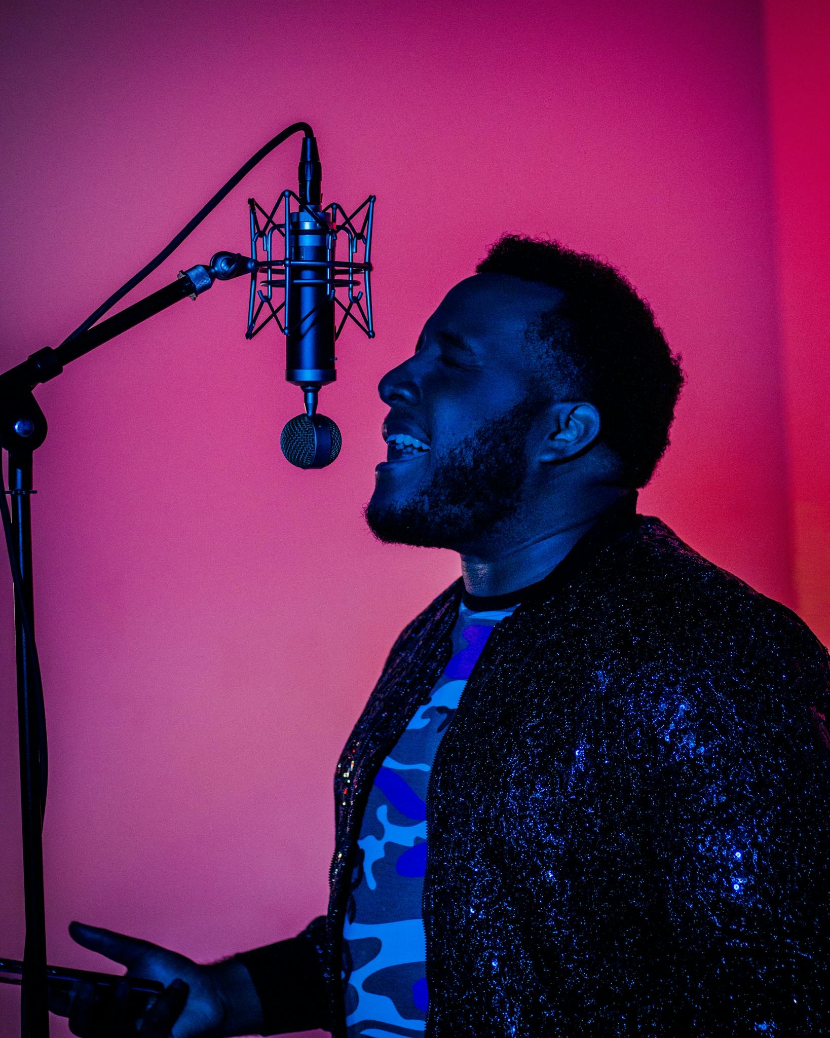 A dynamic portrait of a singer with closed eyes performing passionately in a recording studio.