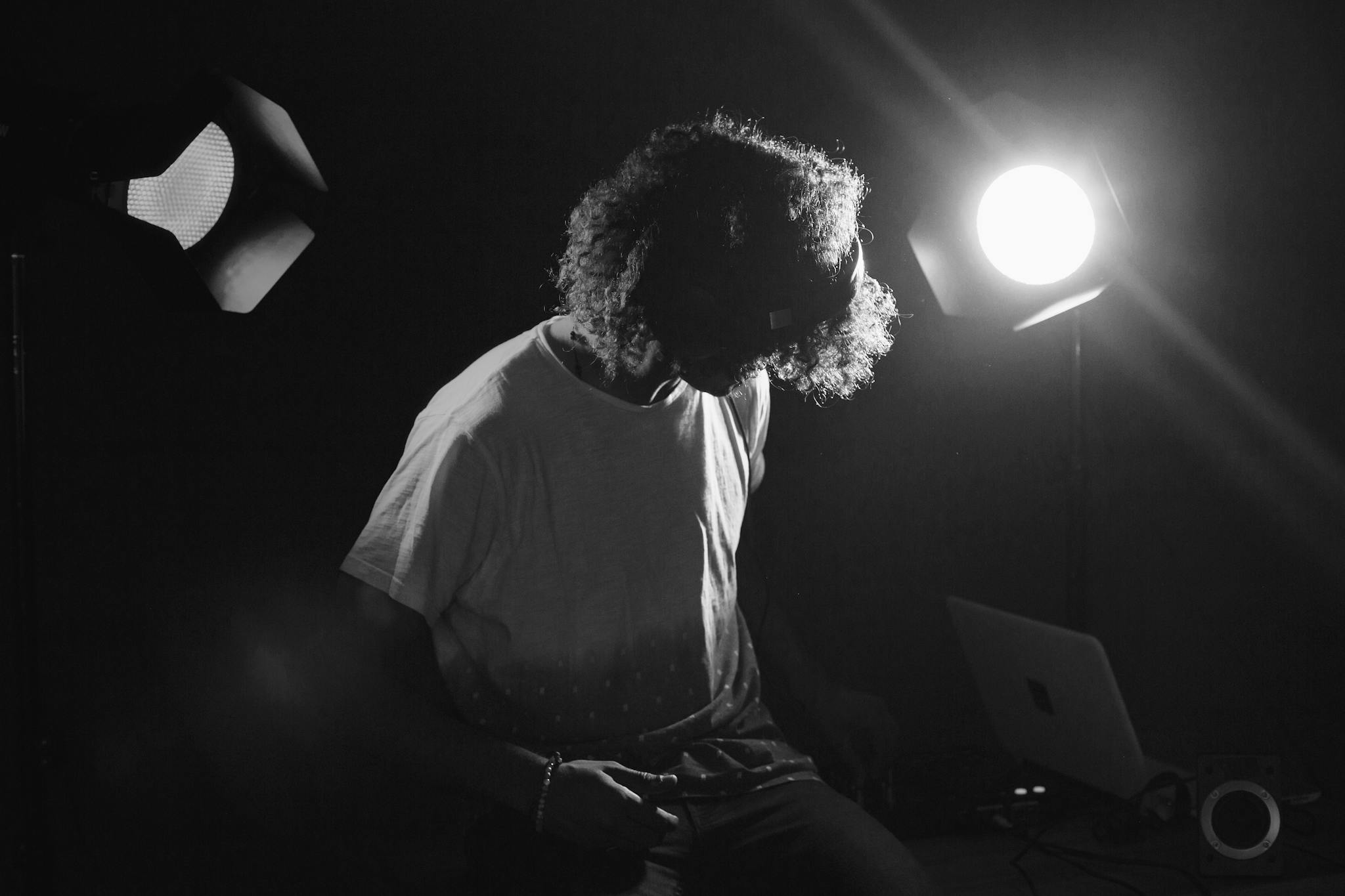 Black and white photo of a musician in a dimly lit studio setting.
